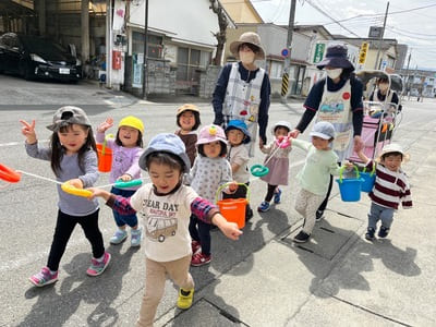 保育士とお散歩をする子供たち